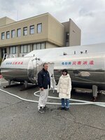 寺谷さん（左）が石川県志賀町に持ち込んだ寺谷建材のタンク２台（提供）