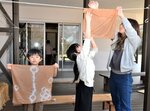 桜色に染まったハンカチを乾かす親子連れ＝２６日、大山町妻木のむきばんだ史跡公園
