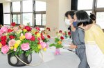 会場に並ぶバラを楽しむ来場者＝２７日、米子市西町の市児童文化センター