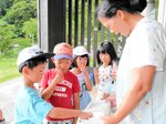 熱中症対策のため屋外活動中に塩分補給をする児童たち＝２５日、香美町村岡区村岡の放課後児童クラブ「ふれあいむらおか」