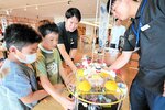 ドローンが浮く様子を眺める子どもたち＝２３日、鳥取市今町２丁目の丸由百貨店