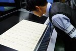 刷り上がった投票用紙を確認する県選管職員＝８日、鳥取市内の印刷会社