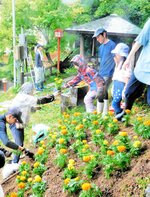 花の苗を植え付ける参加者ら