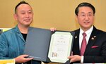 平井知事（右）から任命証を受け取る足立氏＝９日、東京都千代田区の都道府県会館