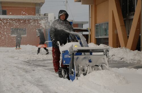 除雪車で市役所前の雪をかく職員＝24日午前７時56分、境港市上道町