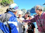 井伊教授（右）から採集した鉱石の種類などを聞く参加者＝香美町香住区の沖の浦鉱山跡