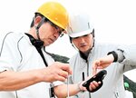 ＩＣＴ化された測量機器の使い方を教わりながら建設業の仕事の魅力を体験する参加者（左）＝豊岡市城崎町