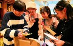 タイムカプセルから出てくる思い出の品に笑顔を見せる若者たち＝７日、倉吉市上井町１丁目のホテルセントパレス倉吉
