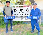 行き先表示板を寄贈した阪口さん（左）