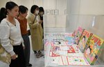 さくらさんの足跡をたどる展示に見入る来館者＝１２日、米子市美術館