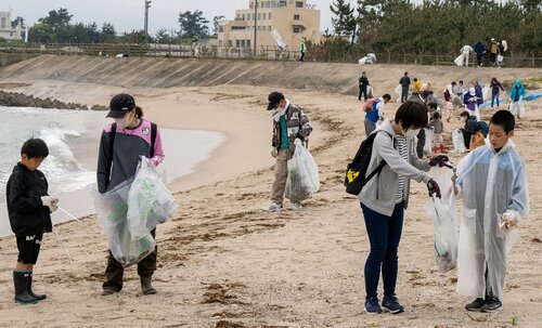 海岸に打ち寄せられたごみを拾う参加者＝１３日、鳥取県米子市両三柳