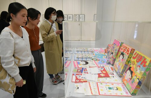 さくらさんの足跡をたどる展示に見入る来館者＝１２日、米子市美術館