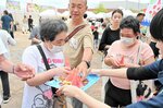 振る舞われたスイカを手に取る来場者＝２２日、倉吉市のエースパック未来中心ふれあい広場