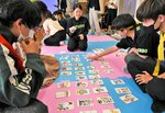 防災かるたを使って災害時の避難行動を学ぶ留学生ら＝２６日、鳥取市若葉台北１丁目の鳥取環境大