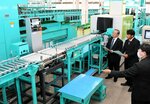 新しい選果機の説明を受ける上本組合長（左）と岸田部会長（中央）