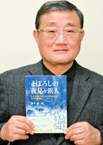 追跡調査の軌跡をまとめた著書「まぼろしの夜見ケ浜人」を手にする根平さん＝境港市内