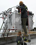 地上約２０メートル先の屋上からはしご車で救出される職員＝２９日、鳥取市伏野の県東部環境クリーンセンター