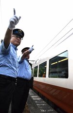 特急やくもの出発合図をする矢中さん（左）＝２６日、日野町根雨のＪＲ根雨駅