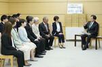 　「ＵＡゼンセン」から署名簿を受け取り、面会する林官房長官（右端）＝１４日午後、首相官邸