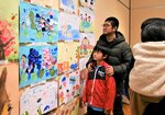 子どもたちの作品を見る来館者