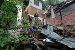 　９日、インドのジャム・カシミールで、パキスタン軍に破壊された建物付近を歩く治安当局者（ゲッティ＝共同）