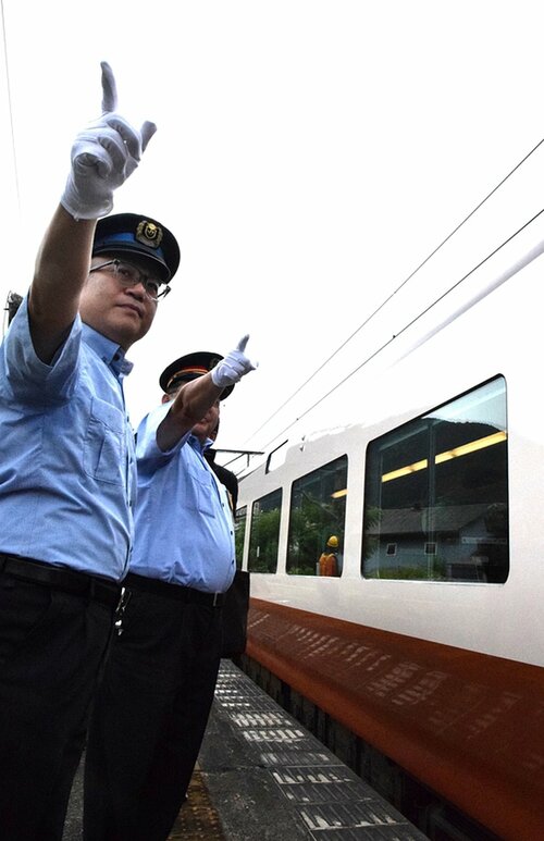 特急やくもの出発合図をする矢中さん（左）＝２６日、日野町根雨のＪＲ根雨駅