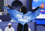 　パリ五輪のブレイキンに出場した難民選手団のマニジャ・タラシュ。英語で「アフガン女性を解放せよ」と書かれたマントを広げた。その後失格となった＝８月９日