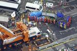 　下水道管内の捜索で発見された遺体を乗せ、陥没事故の現場を離れる車両（右上）＝２日、埼玉県八潮市