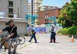 　不発弾らしき物が見つかった広島大霞キャンパス内の工事現場付近で、警戒する警察官＝１３日午後０時２５分、広島市南区