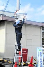カーブミラーを丁寧に清掃するエタニ企業の社員