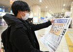 本紙号外をじっくりと読む高校生＝２７日、ＪＲ鳥取駅