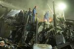 　２４日、ウクライナ首都キーウでロシア軍の弾道ミサイル攻撃の後、がれきを撤去する救助隊員（ＡＰ＝共同）