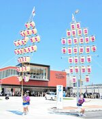 がいなロードの開通を祝い駅南側で披露されたがいな万灯＝２９日、米子市目久美町の駅南広場