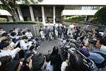　大川原化工機訴訟の東京高裁判決を受け「全面勝訴」と書かれた紙を手に報道陣に囲まれる大川原正明社長（中央）ら＝２８日午後、東京高裁前