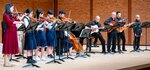 バンドと息の合った弦楽演奏を披露する生徒ら