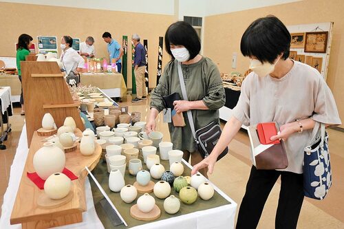  約２千点の中からお気に入りの品を探す来場者＝１３日、倉吉市上井町１丁目の日本海新聞中部本社ホール 