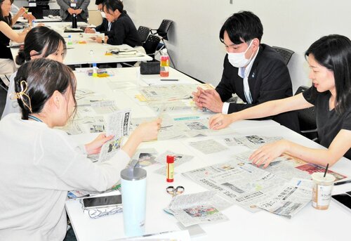 意見を出し合いながら新聞制作に臨む職員ら