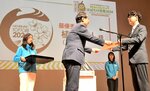 最優秀賞に輝いた植木さん（右）とメダルデザイン（スクリーン）＝４日、鳥取市扇町の県民ふれあい会館