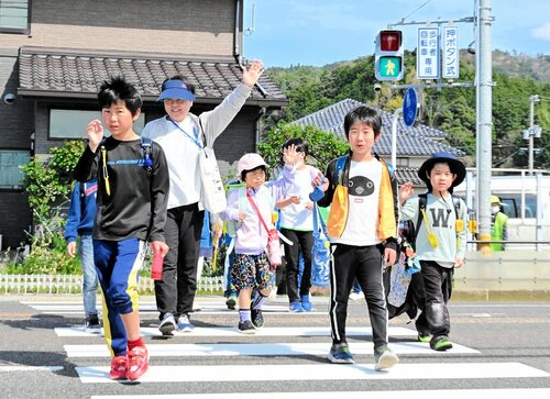 地域の安全ボランティアと一緒に横断歩道を渡る児童たち