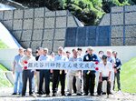 えん堤の完成を祝って記念写真に納まる地区住民ら＝２２日、香美町香住区鎧
