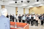 西村町長（手前左）の訓示に耳を傾ける職員ら＝２７日、新温泉町の浜坂多目的集会施設