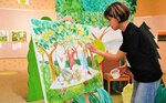 イラスト展の会場で作品を制作する伊吹さん＝２日、倉吉市の鳥取二十世紀梨記念館なしっこ館