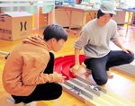 ミニ四駆をコースに走らせる運営スタッフ
