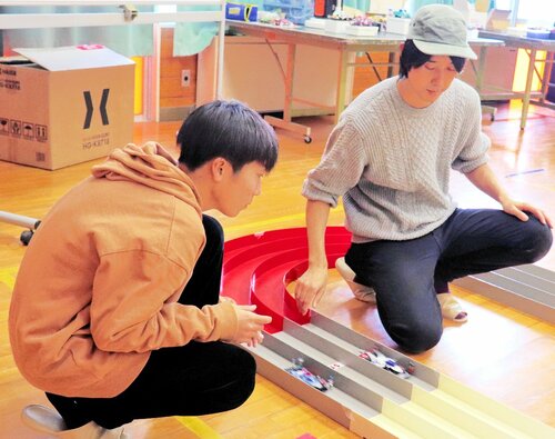 ミニ四駆をコースに走らせる運営スタッフ