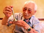 ７８年前の記憶を呼び起こす飛行場から持ち帰ったエンジンのバルブを手にする遠藤さん＝７日、倉吉市内