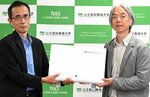 柳沼リーダー（右）から光触媒除菌脱臭機を受け取った小林学長＝１１日、鳥取市若葉台北１丁目の鳥取環境大