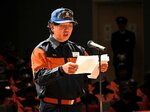新入団員を代表して地域の安心・安全の中核を担うことを誓う守山さん＝１３日、香美町香住区の香住区中央公民館