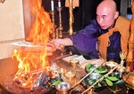高く燃え上がる炎に願い事を書いた木札を入れる郷司住職＝２日、新温泉町前の正楽寺