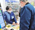 被害防止チェックシート見せながら説得する従業員（左）＝６日、鳥取市秋里のローソン鳥取秋里店