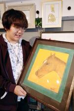 　作品を手に取る画家の小林嵩史さん＝札幌市